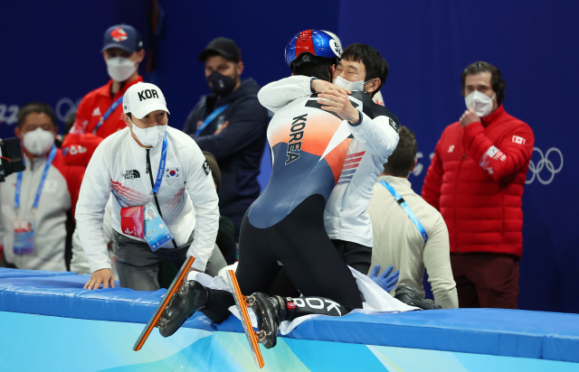한국 쇼트트랙 대표팀 황대헌이 9일 오후 중국 베이징 캐피털 실내 경기장에서 열린 2022 베이징 동계올림픽 쇼트트랙 남자 1500m 결승전에서 금메달을 딴 뒤 김병준, 이영석 코치와 함께 기뻐하고 있다. 연합뉴스