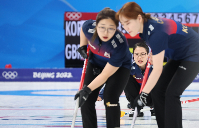 11일 오후 중국 베이징 국립 아쿠아틱 센터에서 열린 2022 베이징 동계올림픽 컬링 여자 단체전 한국과 영국의 경기에서 3앤드 한국 김은정 스킵이 투구한 뒤 리드 김선영(왼쪽)과 세컨드 김초희가 스위핑을 준비하고 있다. 이날 팀 킴은 베이징 올림픽 첫 승을 신고했다. 연합뉴스