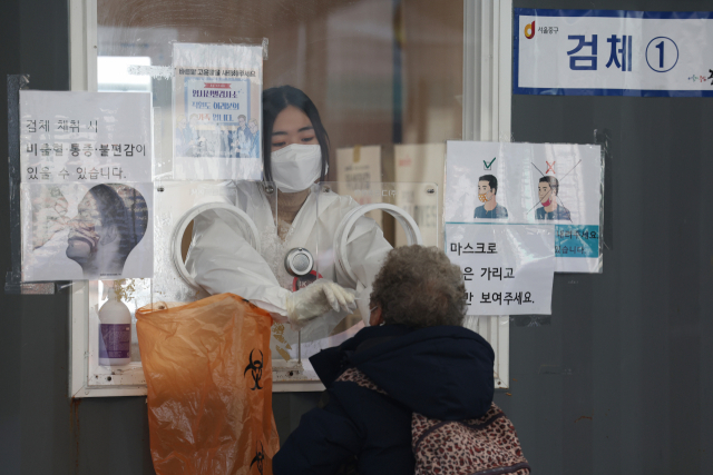 12일 오전 서울 중구 서울역광장에 마련된 코로나19 임시 선별검사소에서 의료진이 검체를 채취하고 있다. 중앙방역대책본부는 이날 0시 기준 코로나19 확진자가 5만4천941명이라고 밝혔다. 연합뉴스