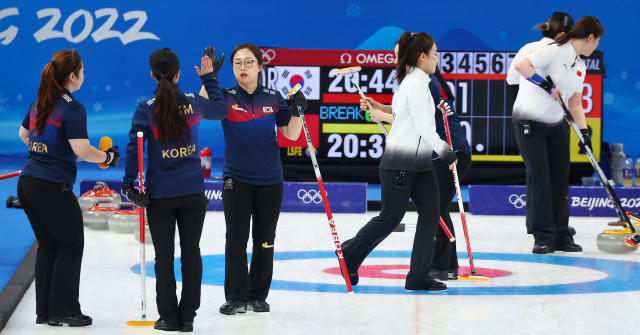 13일 중국 베이징 국립 아쿠아틱 센터에서 2022 베이징 동계올림픽 컬링 여자 단체전 한국과 중국의 경기에서 4앤드 1득점 뒤 팀킴 리드 김선영(왼쪽 세 번째)이 스킵 김은정과 하이파이브를 하고 있다. 연합뉴스