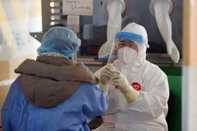 11일 오전 광주 북구선별진료소에서 보건소 의료진이 불안해 하는 시민을 웃으며 맞이하고 있다. 연합뉴스