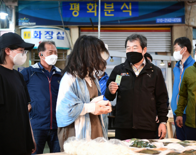 김충섭 김천시장이 전통시장을 방문해 김천사랑상품권(카드)을 사용하고 있다. 김천시 제공