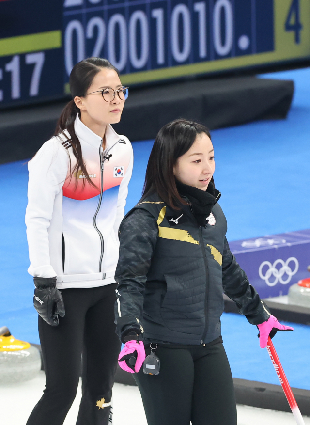 한국 스킵 김은정(왼쪽)과 일본 스킵 후지사와 사쓰키가 14일 오후 중국 베이징 국립 아쿠아틱 센터에서 열린 2022 베이징 동계올림픽 여자 컬링 리그 6차전 한국과 일본의 경기에서 하우스에 나란히 서 있다. 이날 경기에서 한국은 일본에 10대5로 승리를 거뒀다. 연합뉴스
