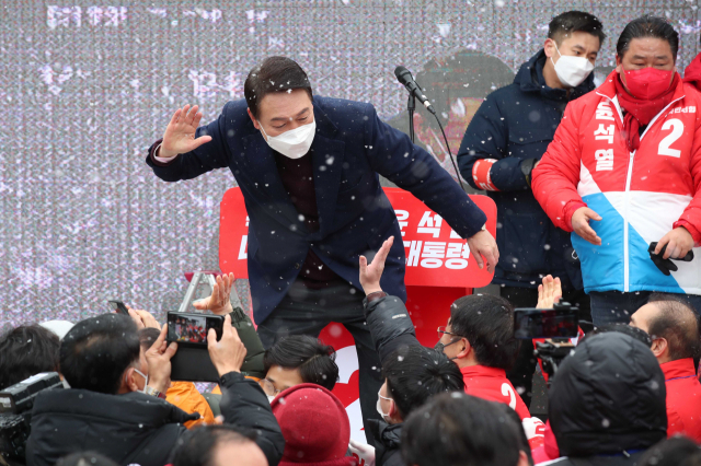 국민의힘 윤석열 대선 후보가 16일 오전 광주 광산구 송정매일시장에서 열린 거점유세에서 발언한 뒤 지지자들과 인사하며 하이 파이브를 하고 있다. 연합뉴스