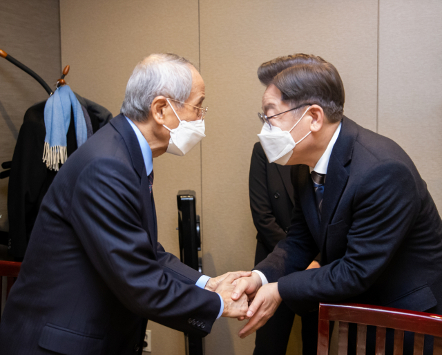 더불어민주당 이재명 대선후보가 8일 저녁 서울시 여의도 한 식당에서 윤여준 전 환경부 장관과 만나 악수하고 있다. 연합뉴스