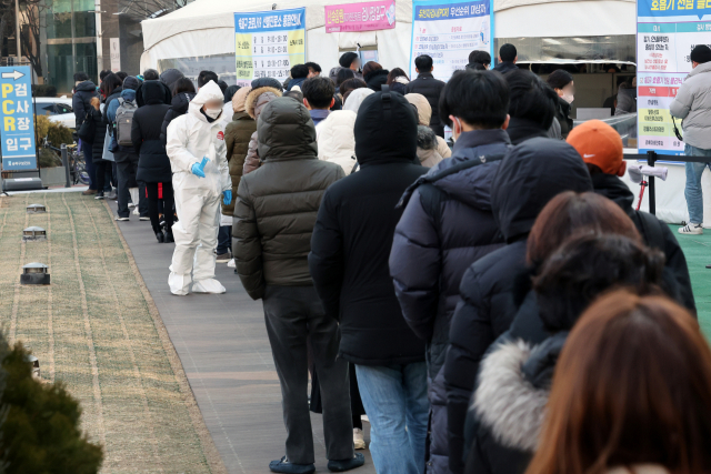 코로나19 사태 후 처음으로 하루 10만 명이 넘는 신규확진자가 발생한 18일 오전 서울 송파구 보건소에 마련된 선별검사소에서 시민들이 검사를 받기 위해 줄을 서 있다. 연합뉴스
