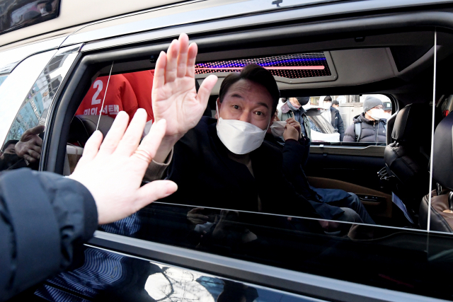국민의힘 윤석열 대선 후보가 18일 오후 대구 달성군 대실역 사거리에서 유세를 마치고 이동하며 카메라를 향해 손을 흔들고 있다. 연합뉴스
