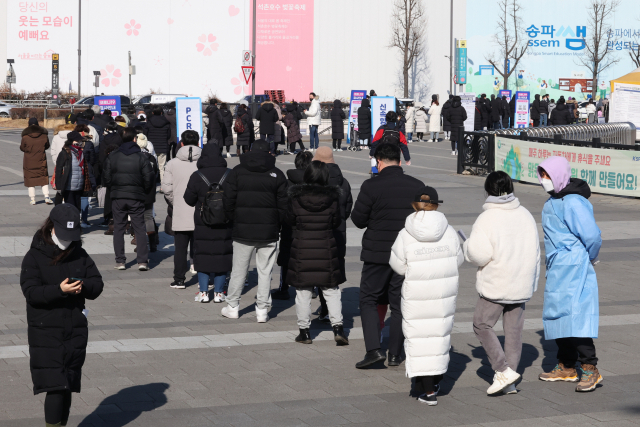 코로나19 사태 후 처음으로 하루 11만명에 육박하는 신규확진자가 발생한 18일 오전 서울 송파구 올림픽공원에 마련된 선별검사소에서 시민들이 검사를 받기 위해 줄을 서 있다. 연합뉴스