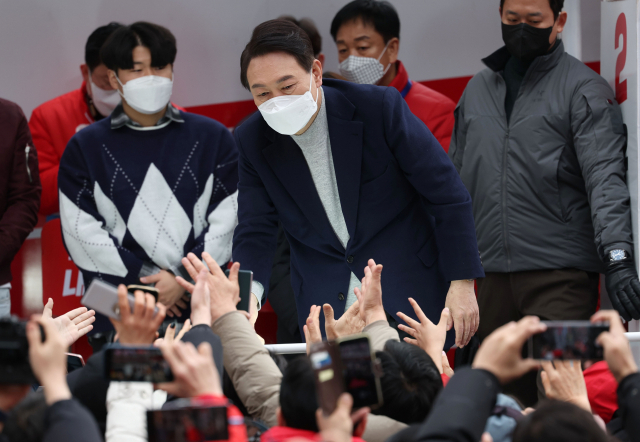 국민의힘 윤석열 대선 후보가 19일 오전 울산 롯데백화점 울산점 앞에서 유세를 한 뒤 지지자들과 악수하고 있다. 연합뉴스