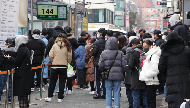 서울의 코로나19 신규 확진자 수가 이틀 연속 2만명대를 기록한 19일 서울 중구보건소 선별진료소 앞에서 코로나19 검사를 받기 위해 시민들이 대기하고 있다. 연합뉴스