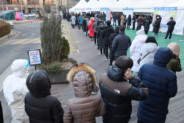 코로나19 사태 후 처음으로 하루 11만명에 육박하는 신규확진자가 발생한 지난 18일 오전 서울 송파구 보건소에 마련된 선별검사소에서 시민들이 검사를 받기 위해 줄을 서 있다. 연합뉴스