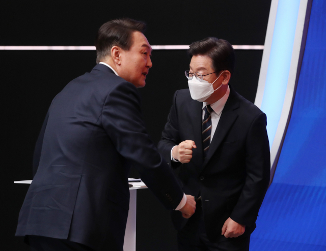 국민의힘 윤석열 대선 후보(왼쪽)와 더불어민주당 이재명 대선 후보가 21일 오후 서울 마포구 MBC 미디어센터 공개홀에서 열린 중앙선거방송토론위원회 주관 제20대 대통령선거 후보 초청 1차 토론회 시작에 앞서 인사하고 있다. 연합뉴스
