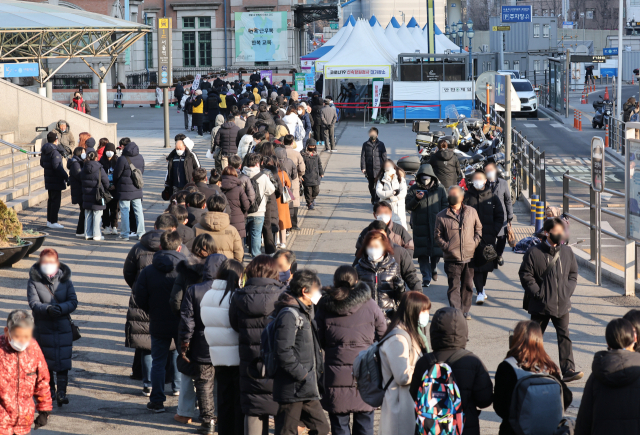 코로나19 변종 오미크론 확산세가 거센 가운데 지난 21일 오전 서울 중구 서울역 코로나19 임시 선별검사소에서 시민들이 검사를 받기 위해 줄을 서 있다. 연합뉴스