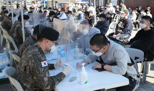 지난해 3월 대구 북구 육군 제50사단에서 열린 현역병 입소식에서 입영 장병들이 코로나19 관련 문진표를 작성하고 있다. 매일신문DB