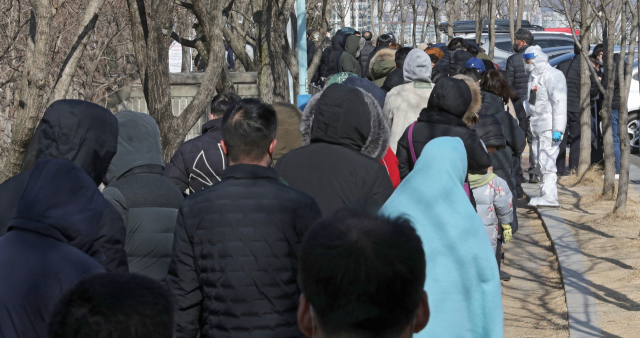 22일 오후 대구 수성구 대구스타디움 제3주차장에 마련된 임시선별검사소에서 시민들이 코로나19 진단검사를 받기 위해 순서를 기다리고 있다. 중앙방역대책본부는 이날 0시 기준으로 신규 확진자가 9만9,573명 늘어 누적 215만7,734명으로 집계됐다고 밝혔다. 김영진 기자 kyjmaeil@imaeil.com
