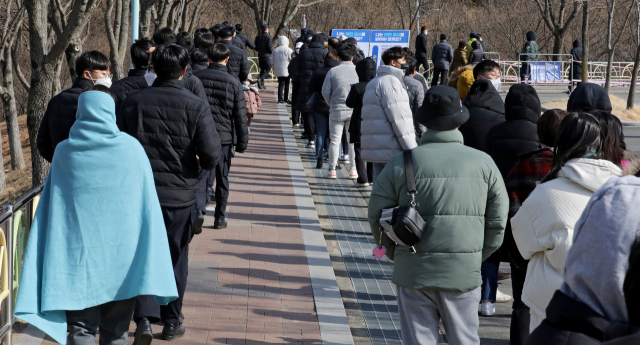22일 오후 대구 수성구 대구스타디움 제3주차장에 마련된 임시선별검사소에서 시민들이 코로나19 진단검사를 받기 위해 순서를 기다리고 있다. 중앙방역대책본부는 이날 0시 기준으로 신규 확진자가 9만9,573명 늘어 누적 215만7,734명으로 집계됐다고 밝혔다. 김영진 기자 kyjmaeil@imaeil.com