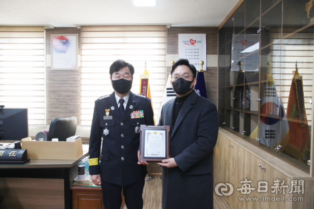 아파트 베란다에서 발생한 화재를 진압한 이웃 주민인 조효재(오른쪽) 씨에게 정윤재 경산소방서장이 표창장을 주고 있다. 경산소방서 제공