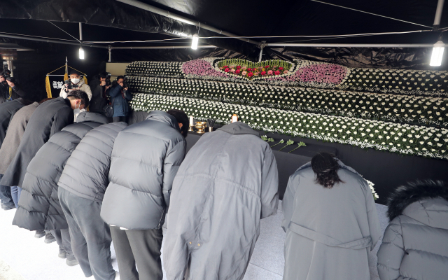 12일 오전 광주 서구 화정아이파크 붕괴 현장 인근에 마련된 합동분향소에서 유가족이 참배하고 있다. 시공사인 HDC 현대산업개발 측의 사과와 보상 약속을 요구하며 장례를 치르지 않고 있는 유가족 측은 영정사진과 위패 등을 분향소에 안치하지 않았다. 연합뉴스