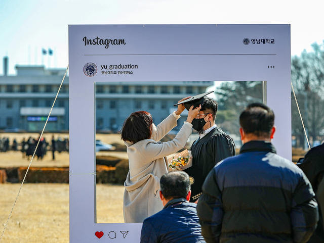 22일 영남대학교가 2021학년도 전기 학위수여식을 열었다. 캠퍼스에서 기념촬영을 하는 학생과 가족들의 모습. 영남대 제공