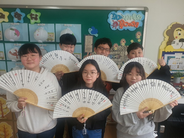 김세환 교장으로부터 부채를 선물받은 칠곡초등학교 졸업생들. 대구시교육청 제공