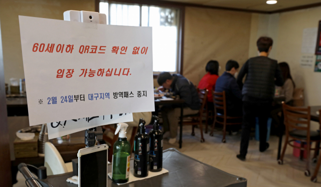 24일 오전 대구 중구의 한 식당에서 관계자가 방역패스 안내문을 붙이고 있다. 대구지법은 청소년 방역패스에 이어 60세 미만에 대한 식당·카페 방역패스 효력정지 결정을 내렸다. 김영진 기자 kyjmaeil@imaeil.com