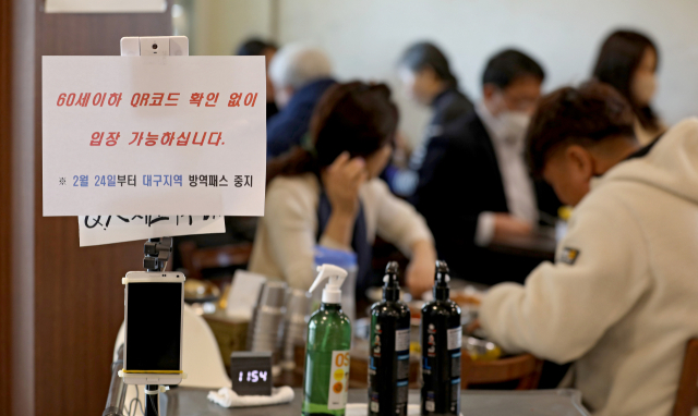 24일 오전 대구 중구의 한 식당에서 관계자가 방역패스 안내문을 붙이고 있다. 대구지법은 청소년 방역패스에 이어 60세 미만에 대한 식당·카페 방역패스 효력정지 결정을 내렸다. 김영진 기자 kyjmaeil@imaeil.com