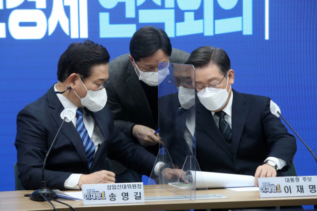 더불어민주당 송영길 대표와 이재명 대선 후보가 24일 오후 서울 여의도 중앙당사에서 열린 긴급 안보경제 연석회의에서 대화하고 있다. 가운데는 강병원 의원. 연합뉴스
