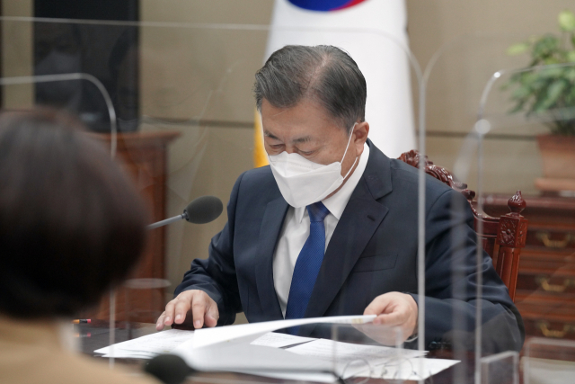 문재인 대통령이 25일 오전 청와대 여민관 소회의실에서 열린 글로벌 에너지 공급망 현안 점검회의에서 문승욱 산업통상자원부 장관으로부터 보고 받고 있다. 연합뉴스
