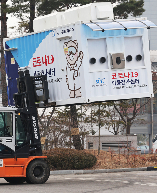 25일 오후 경기도 용인시 기흥구 서울의과학연구소에서 지게차가 코로나19 이동검사센터를 옮기고 있다. 교육부는 학생·교직원 대상 현장 이동형 PCR 검사소를 운영해 학교에 확진자가 발생하면 접촉자의 감염 여부를 빠르게 진단한다는 계획이다. 연합뉴스