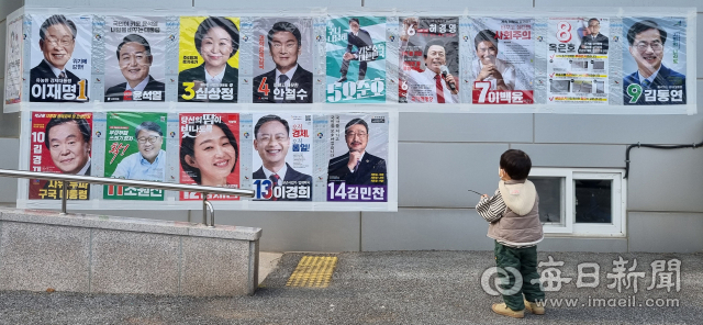 제20대 대통령선거 사전투표를 닷새 앞둔 27일 한 아이가 경북 울진군 북면 덕구온천리조트 담장에 붙은 각 후보들의 선거 벽보를 바라보고 있다. 정운철 기자 woon@imaeil.com