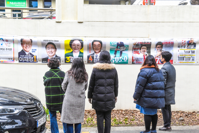 지난 25일 제주시 연동 소재 제주특별자치도교육청 외벽에 첩부된 제20대 대통령선거 후보 벽보를 시민들이 둘러보고 있다. 제주일보 고봉수 기자
