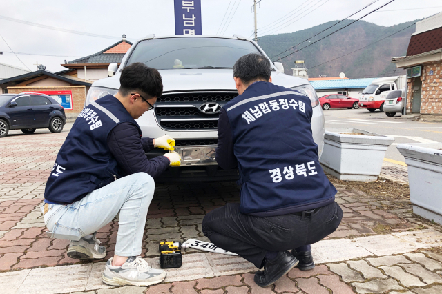 청송군 체납합동징수팀이 자동차세 체납 차량에 대해 번호판을 영치하는 모습. 청송군 제공