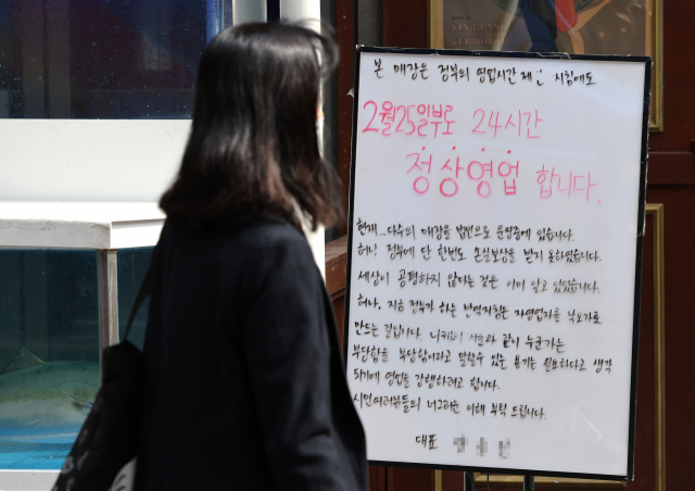 정부가 다음 달 1일 0시부터 식당·카페 등 11종 다중이용시설 전체에 대한 방역패스 적용을 일시 중단하기로 결정한 28일 서울의 한 음식점 입구에 24시간 영업을 알리는 대표의 글귀가 써져 있다. 연합뉴스
