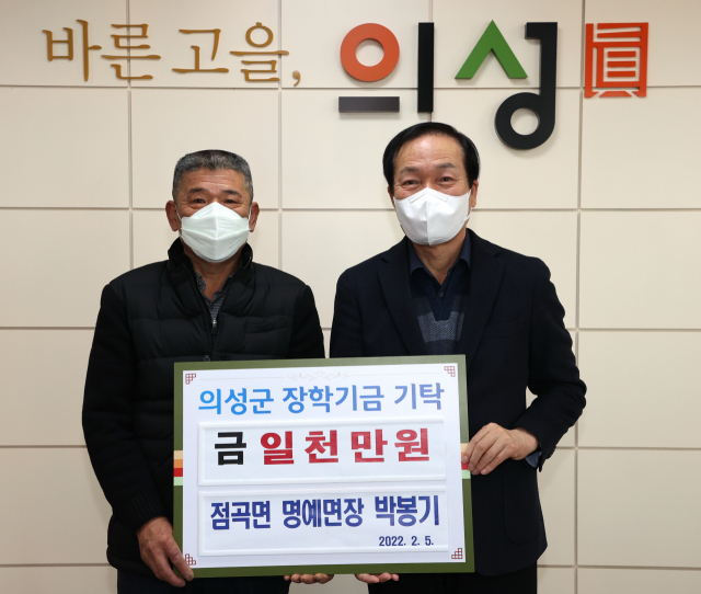 경북 의성군 점곡면 박봉기(왼쪽) 명예면장이 김주수 의성군수에게 장학금 1천만원을 기탁하고 기념 사진을 촬영하고 있다. 의성군 제공