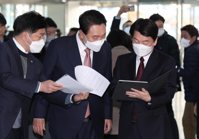 국민의힘 윤석열 대선 후보와 국민의당 안철수 대선 후보가 3일 오전 국회 소통관에서 단일화 기자회견을 하기 전 최종적으로 합의문을 살펴보고 있다. 연합뉴스