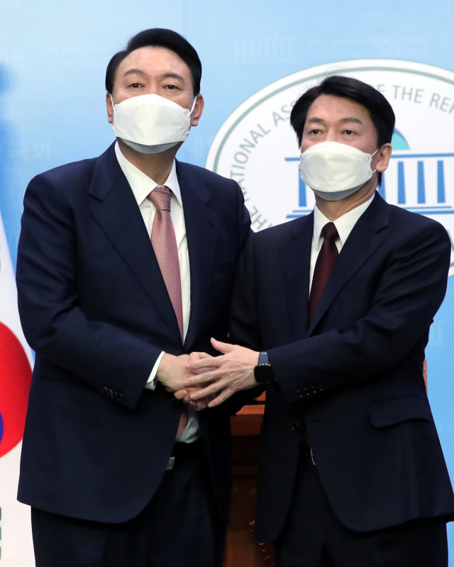 국민의힘 윤석열 대선 후보와 국민의당 안철수 대선 후보가 3일 오전 국회 소통관에서 단일화 기자회견을 마치며 악수하고 있다. 연합뉴스