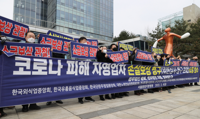 코로나 피해 자영업 총연대(코자총) 관계자들이 4일 오전 서울 서초구 서울행정법원 앞에서 기자회견을 열고 코로나 피해 자영업자 손실보상 청구 소장 접수에 앞서 손실보상을 촉구하며 구호를 외치고 있다. 연합뉴스