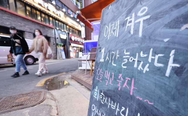 정부가 5일부터 20일까지 적용되는 새로운 거리두기 방침을 발표한 4일 오후 서울 종로의 한 식당 앞에 방역지침을 비판하는 간판이 세워져 있다. 정부 방침에 따르면 전국적으로 오후 10시까지로 제한되던 식당, 카페, 유흥시설 등을 비롯한 다중이용시설의 영업시간이 11시까지로 연장되며, 사적모임인원은 6인으로 유지된다. 정부는 다음번 거리두기 조정에서 본격적인 완화조치를 검토하기로 했다. 연합뉴스