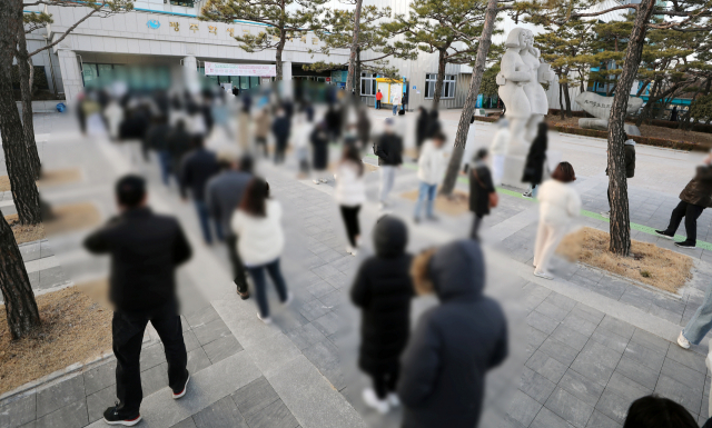 제20대 대통령선거 사전 투표 이틀째인 5일 오후 광주 서구 학생교육문화회관에 마련된 상무1동 사전투표소에서 확진·격리자들이 사전투표를 하기 위해 길게 줄을 서 있다. 최근 확진자가 일 20만명 이상 수준으로 폭증하며 격리 생활을 해야 하는 유권자 역시 늘었지만, 단 1시간 30분에 불과한 사전투표 시간은 부족했다는 비판이 나오고 있다. 연합뉴스