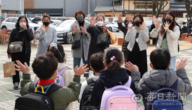 3월은 초등학교에 갓 입학한 새내기들의 학교 적응기. 8일 대구 종로초등학교 정문에서 마중나온 엄마들이 1학년 신입생 자녀들을 향해 손을 흔들고 있다. 정운철 기자 woon@imaeil.com
