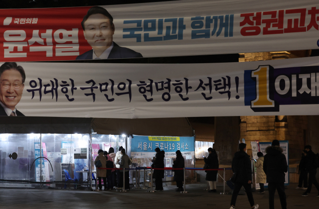제20대 대통령선거를 하루 앞둔 8일 오후 독립문 광장에 마련된 코로나19 선별검사소에 시민들이 PCR 검사를 받기 위해 줄을 서서 기다리고 있다. 서울시 등 각 지방자치단체에 따르면 이날 0시부터 오후 6시까지 전국 17개 시도에서 코로나19 확진 판정을 받은 사람은 26만3천523명으로 집계됐다. 전날 같은 시간대 집계치인 17만6천86명보다 8만7천437명 많다. 연합뉴스