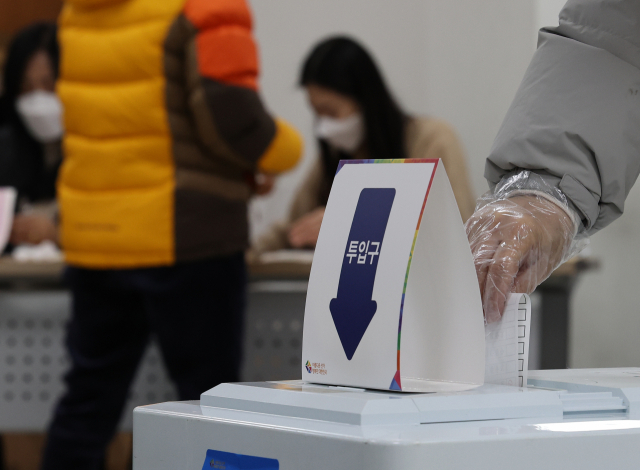 제20대 대통령선거 투표일인 9일 오전 서울 송파구 석촌동 주민센터에 마련된 석촌동 제1투표소에서 비닐장갑을 낀 유권자가 투표용지를 투표함에 넣고 있다. 연합뉴스