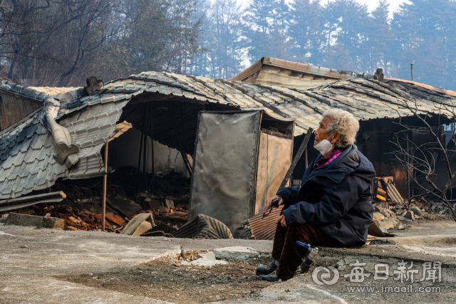 울진 산불 발생 닷새째인 8일 오전 울진군의 한 마을에서 집을 잃은 주민이 집을 바라보며 눈물을 흘리고 있다. 메일신문DB
