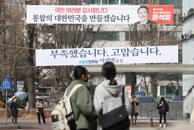 11일 서울 한 아파트 단지 앞에 내걸린 윤석열 대통령 당선인과 더불어민주당 이재명 대선 후보 메시지. 연합뉴스