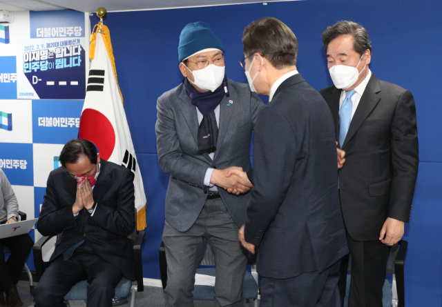 더불어민주당 이재명 대선 후보가 10일 오후 서울 여의도 중앙당사에서 열린 선대위 해단식에서 이낙연 총괄선대위원장, 송영길 대표와 인사하고 있다. 우상호 총괄선대본부장(왼쪽)은 눈물을 훔치고 있다. 연합뉴스