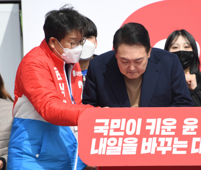 국민의힘 윤석열 대선 후보가 28일 오전 강원 동해시청 앞에서 열린 유세에서 권성동 의원과 대화하고 있다. 연합뉴스
