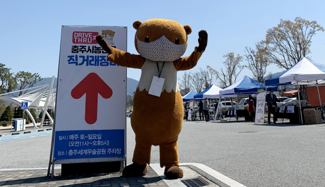 충주씨가 드라이브인스루 농산물 판매장에서 시민들을 맞이하고 있다.