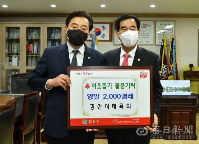 강영근(왼쪽) 경산시체육회장이 15일 최영조 경산시장에게 400만원 상당의 양말 2천 켤레를 기탁했다. 경산시 제공