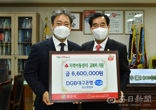 DGB대구은행 경산영업부 윤수왕(왼쪽) 부장은 15일 최영조 경산시장에게 아동센터를 이용하고 있는 중·고등학교 재학생 교복 구입비로 성금 660만 원을 기탁했다.