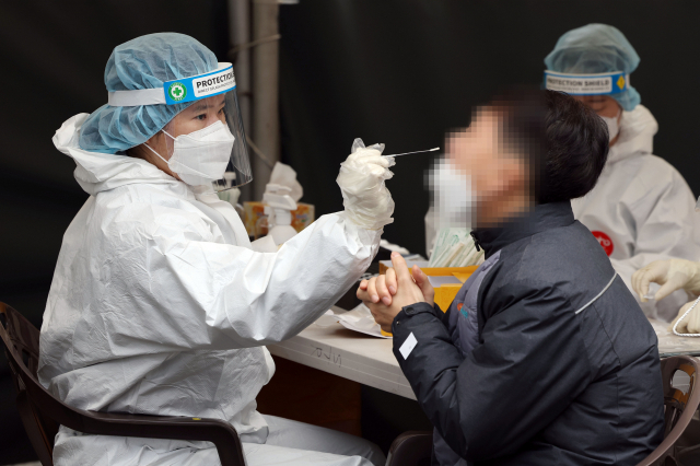 18일 서울역 광장에 마련된 코로나19 임시 선별검사소에서 의료진이 검체를 채취하고 있다. 연합뉴스